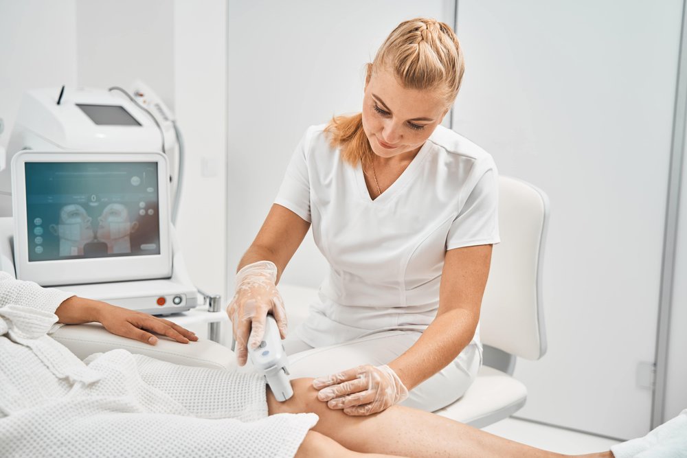 cheerful-cosmetologist-holding-gadget-for-laser cheerful cosmetologist holding gadget for laser